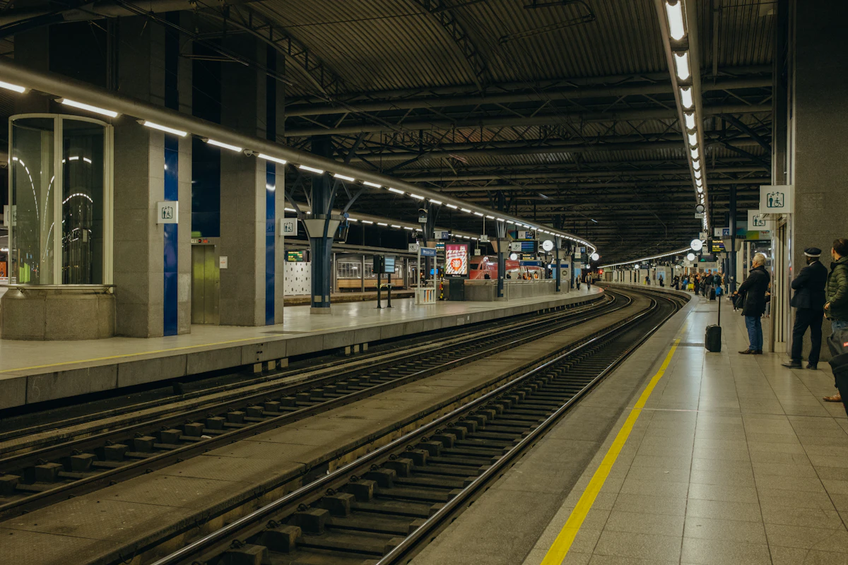 Cheap airport transfers Europe: passengers on a railway platform, illustrating transfer connections and waiting time.