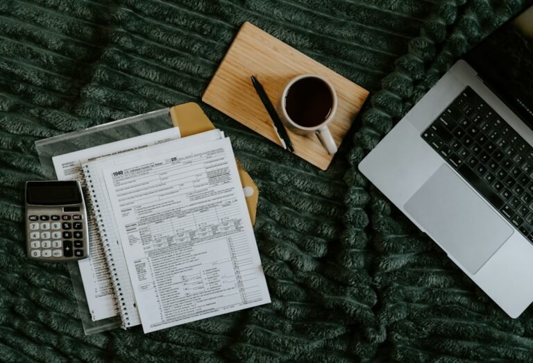 Laptop, calculator and paperwork illustrating UK side hustle tax and HMRC's £1,000 trading allowance