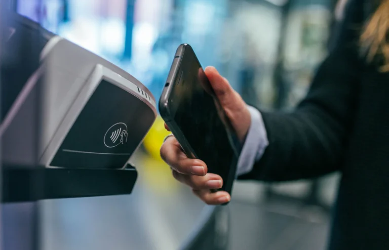 Phone held near a card payment terminal, illustrating overseas card payments